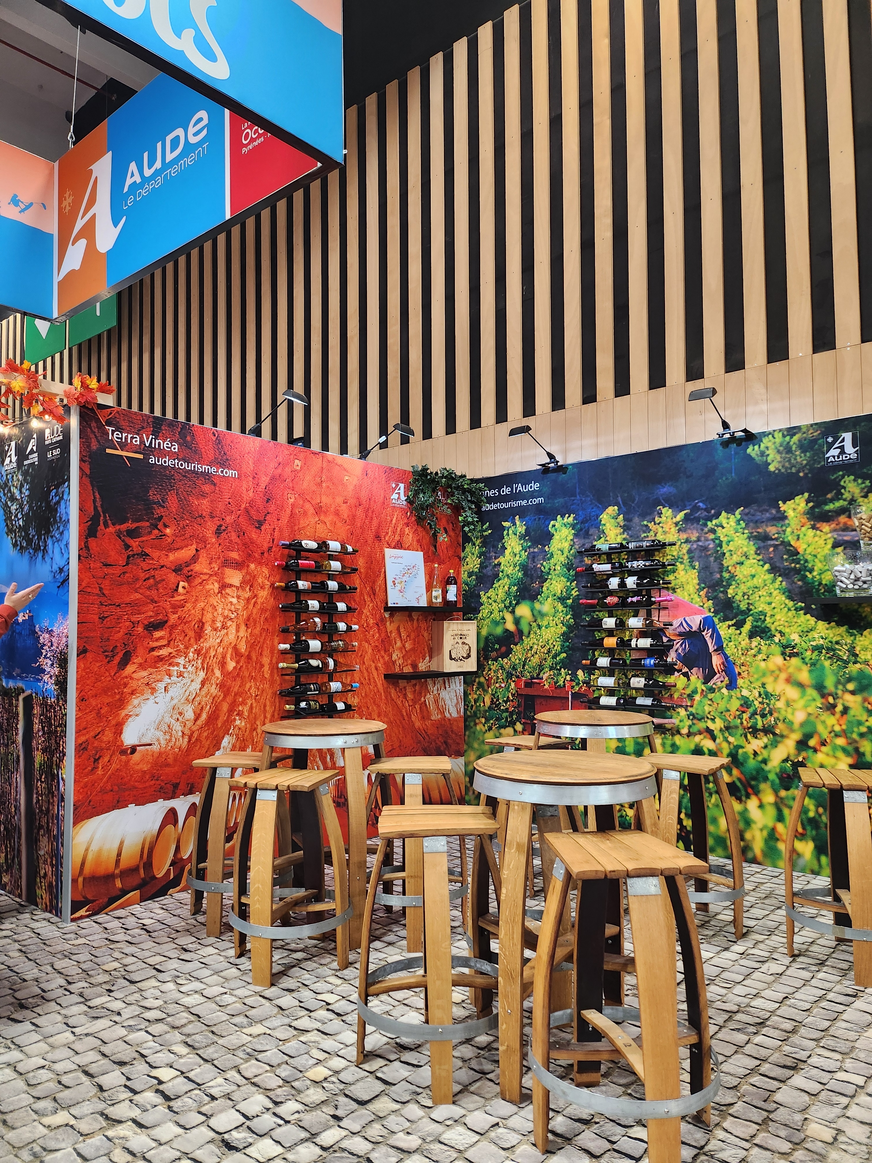 Espace dégustation avec tabourets et tables hautes sur un sol imitation pavé au salon de l'agriculture