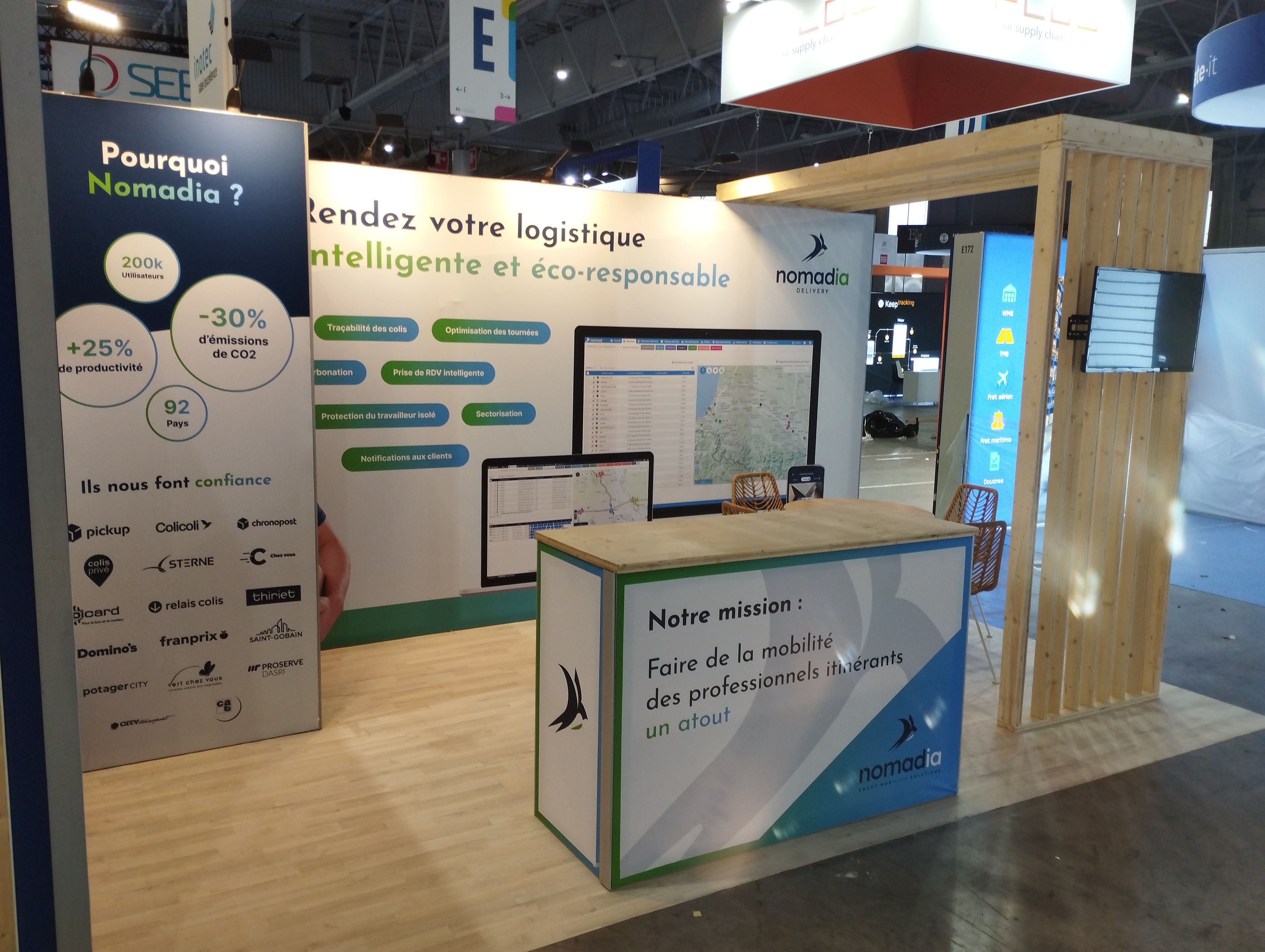 Stand de Nomadia au SITL 2024 avec desk d'accueil en bois