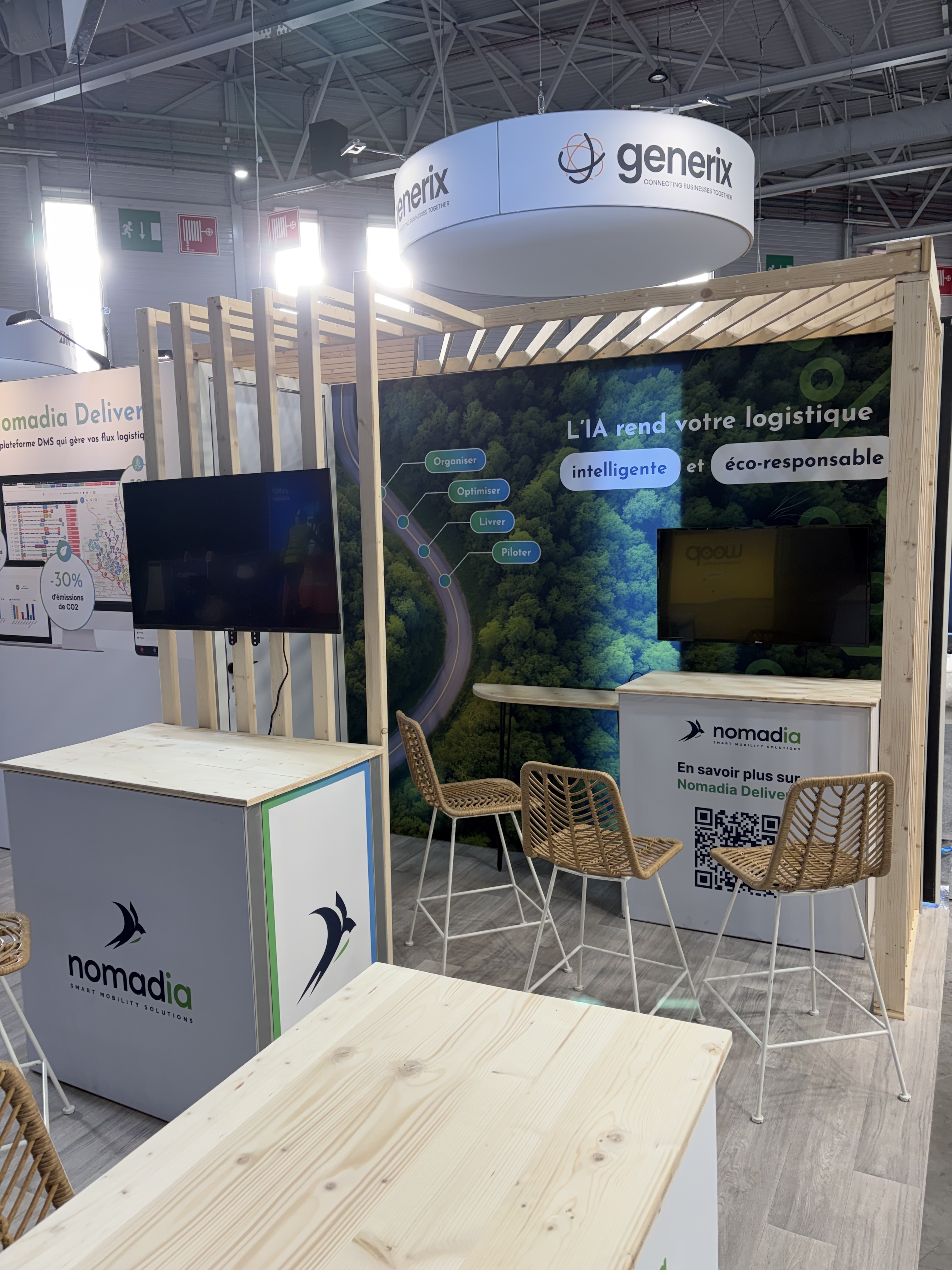Stand de Nomadia au SITL 2026 à Paris avec écran sur une claustra bois