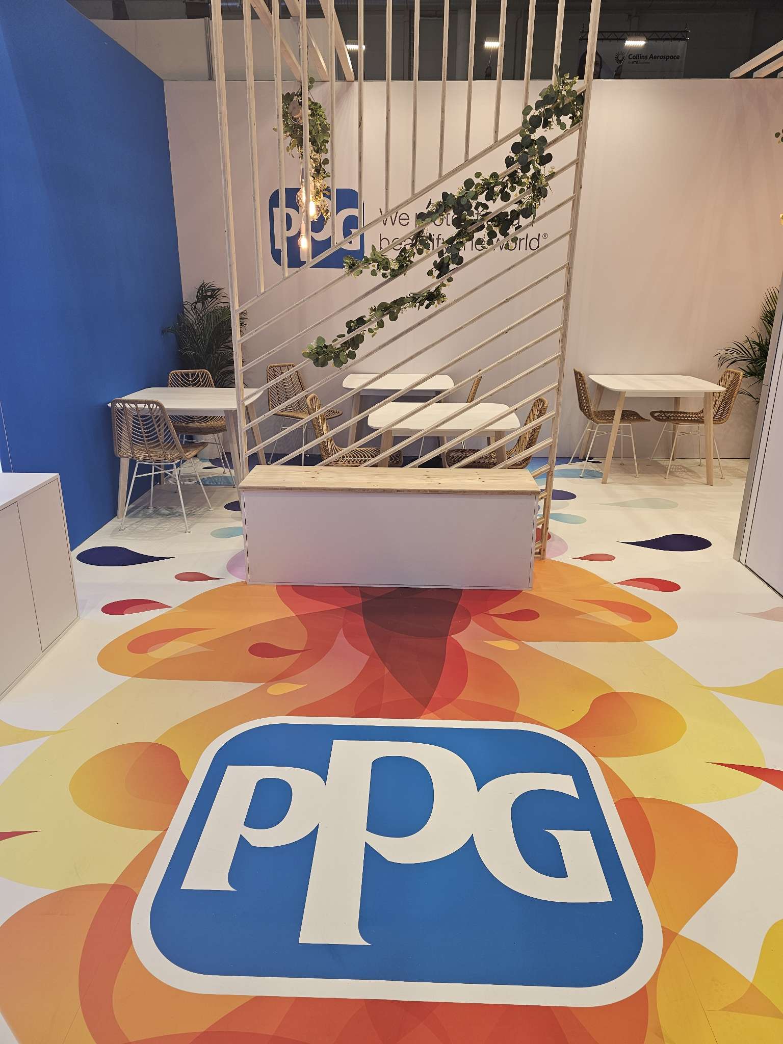 claustra en bois et coffre en bois, avec un sol personnalisé coloré en jaune, orange et rouge et le logo de PPG
